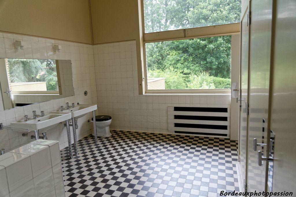 Salle de bain avec placards de rangement. On retrouve le même carrelage au sol que dans les cuisines.